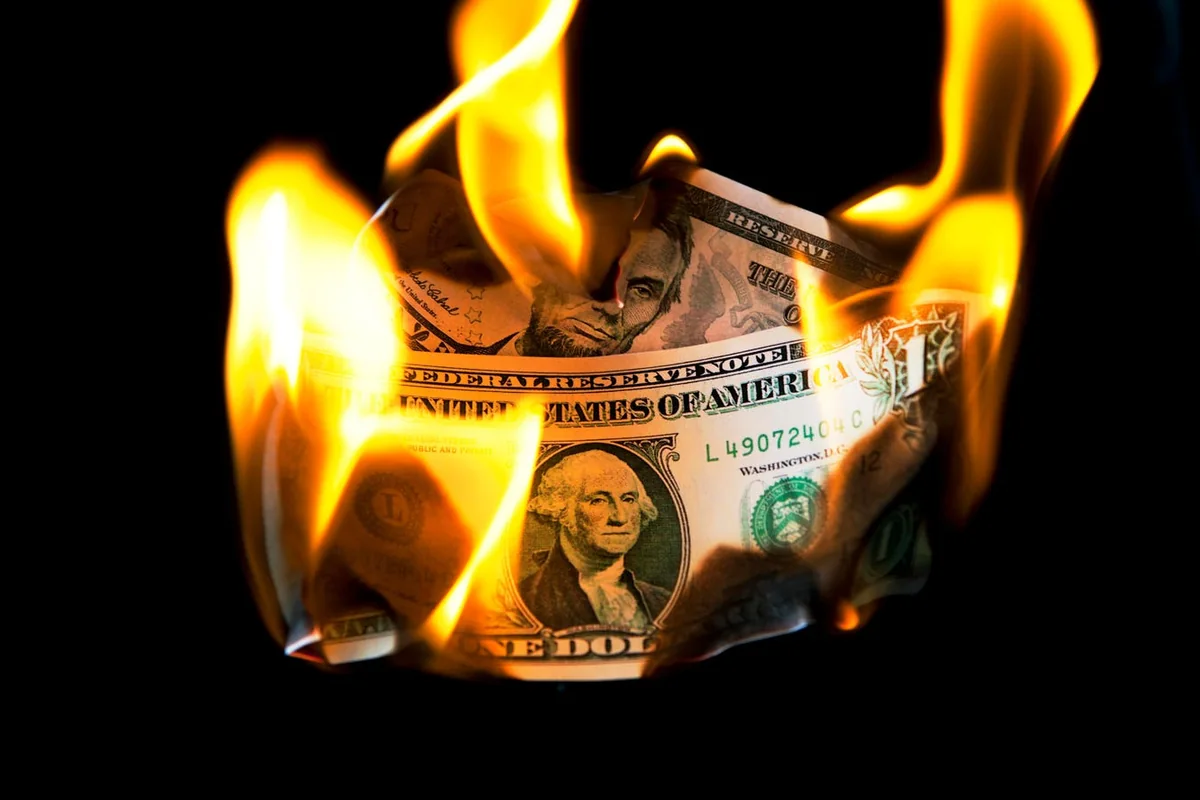 Burning dollar banknotes in the photograph accompanying Forbes’s article on model costs.