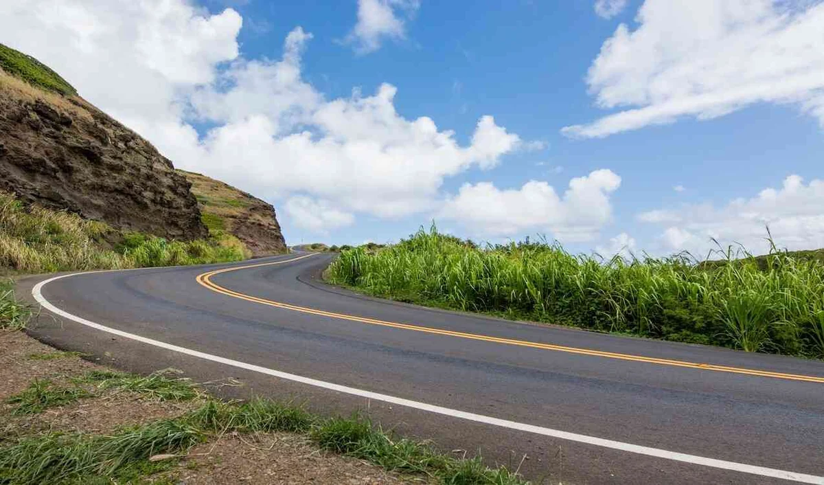 Winding road through green hills under a blue sky