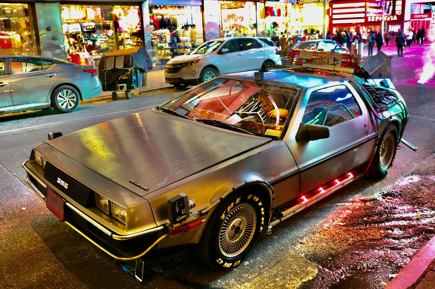 Voiture de sport dans une rue éclairée la nuit.