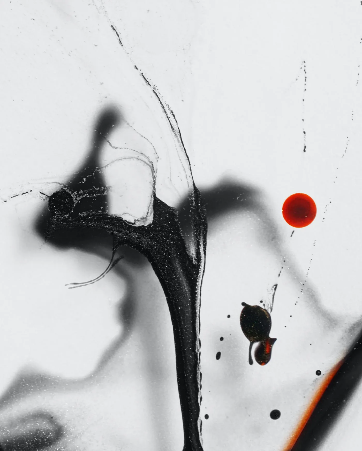 Encre noire et gouttes rouges sur un fond clair.