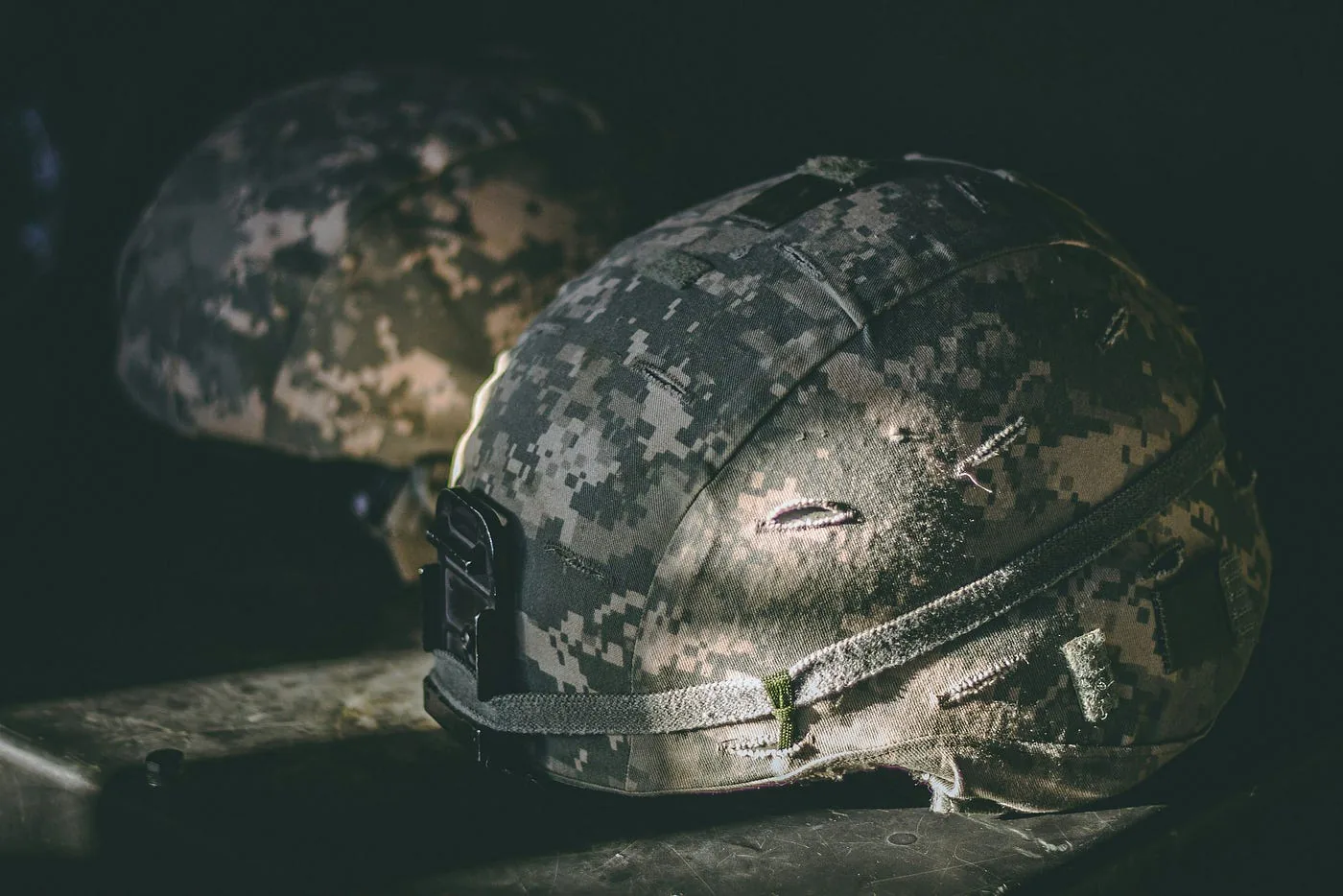 Camouflage helmets on a table.