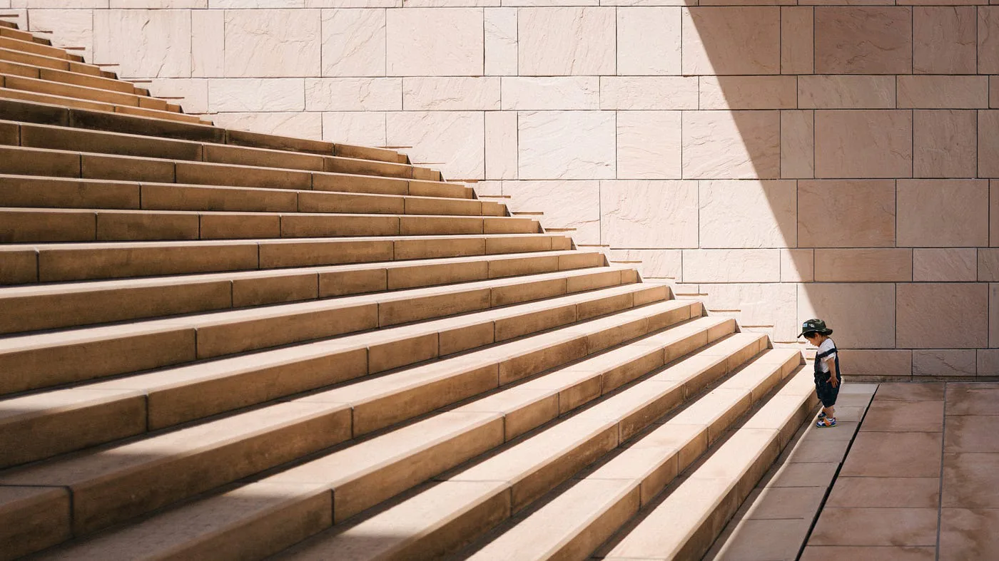 Un enfant devant un grand escalier.